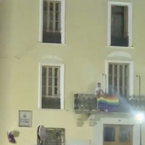 Un individu lleva la bandera LGTBIQ+ de l’Ajuntament d’Albaida